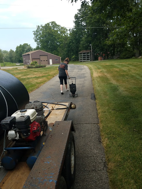 Here Amie is pulling a bander. this tool is used for applying hot rubber crack fill to crack's.